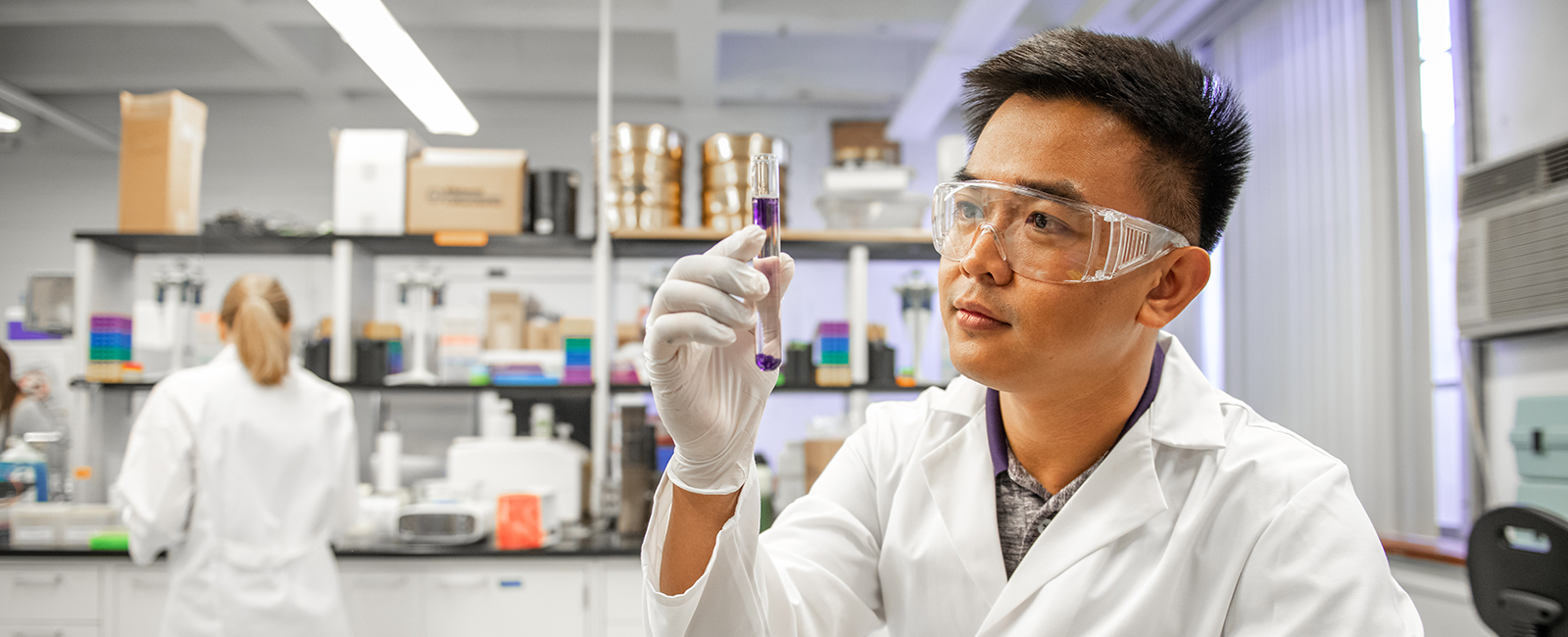 A student inspects liquid in a test tube in a lab.